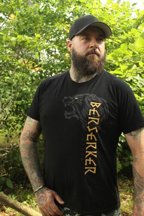 Zwei Kunden in Wikinger-Shirts posieren sitzend auf einem Felsen