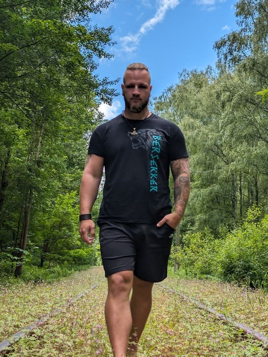 Kundin im Shirt mit Wolfsmotiv steht in hohem Gras