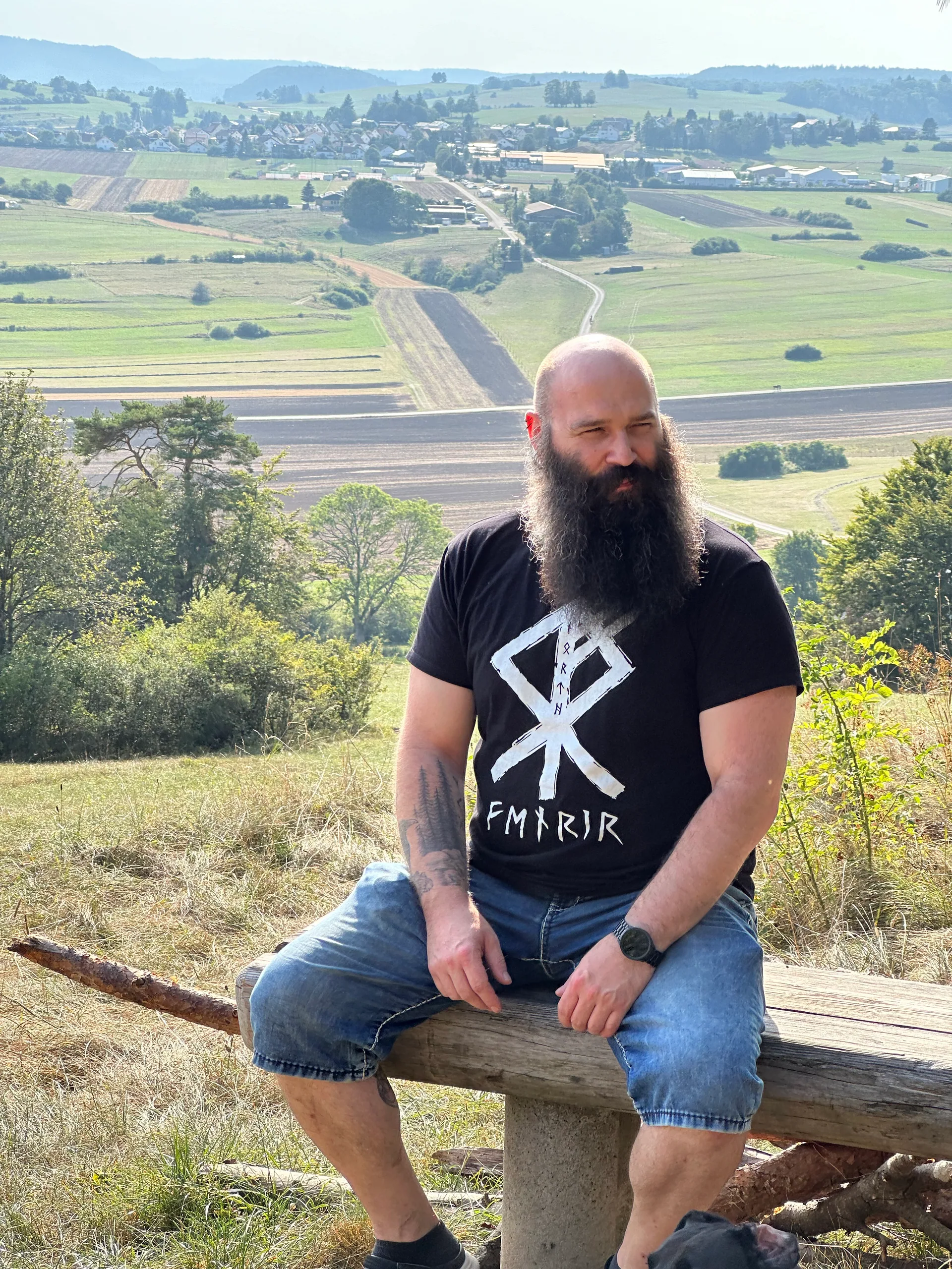 Mann mit langem Bart auf einer Holzbank über einer Bergpanorama, North Legendary Runen-Shirt